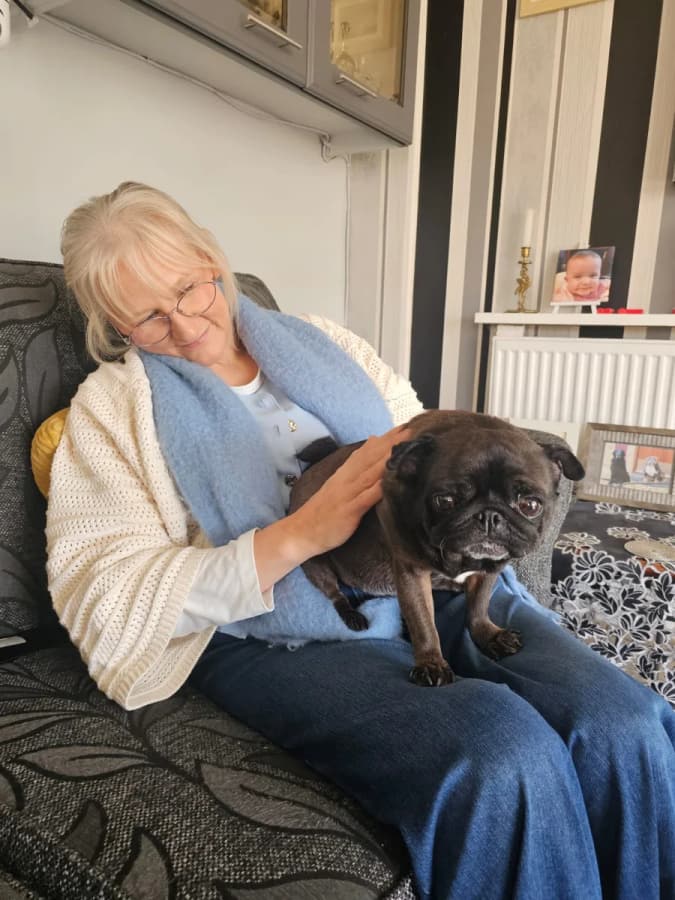 A home boarder giving a black dog a cuddle