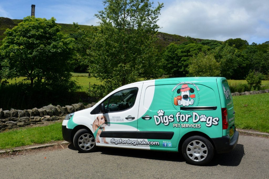 A green Digs for Dogs van ready for the day